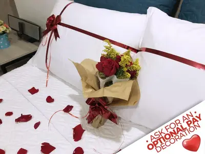 a bouquet of roses sitting on a bed with hearts at New Studio Apartment for Two in Medellín