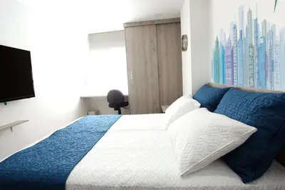 a bedroom with a blue and white bed with a window at New Studio Apartment for Two in Medellín