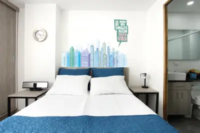a bedroom with a blue and white bed and a window at New Studio Apartment for Two in Medellín