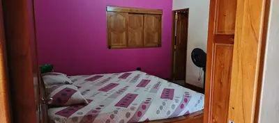 a small bedroom with a bed with purple walls at Finca campestre y recreativa los potrillos in Doradal