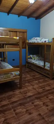 two bunk beds in a room with wooden floors at Finca campestre y recreativa los potrillos in Doradal