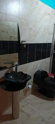 a bathroom with a black sink and a toilet at Finca campestre y recreativa los potrillos in Doradal