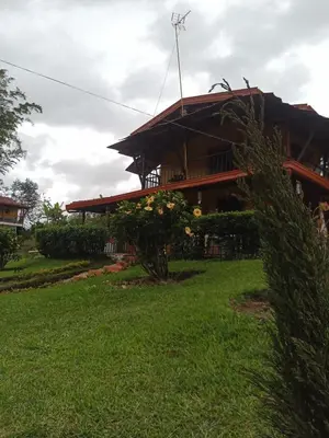 a house with a green yard in front of it at Finca Alejandria (Condominio la Chiquita) in Marinilla