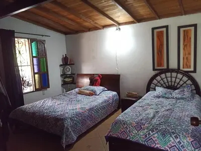 a bedroom with two beds and a window at Finca Alejandria (Condominio la Chiquita) in Marinilla