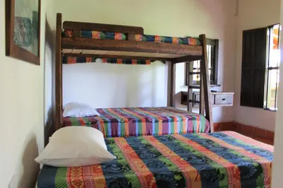 a bedroom with two beds and a bunk bed at Las Orquídeas EcoHostel in Guarne