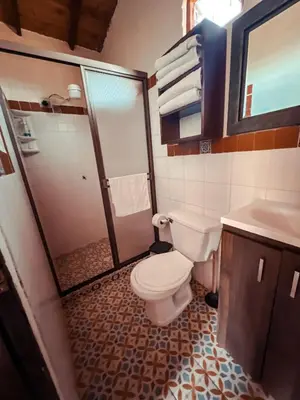a bathroom with a toilet and a shower and a sink at Las Orquídeas EcoHostel in Guarne