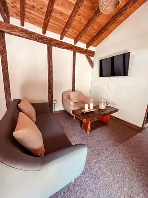 a living room with a couch and a tv at Las Orquídeas EcoHostel in Guarne