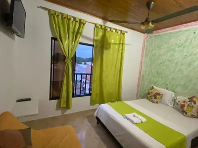 a bedroom with a bed and a window with green curtains at Hotel imperial in Doradal