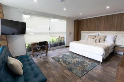 a bedroom with a bed and a tv and a couch at Libertg Hotels Medellin in Copacabana
