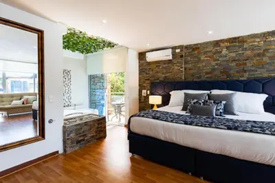 a bedroom with a large bed and a mirror at Libertg Hotels Medellin in Copacabana