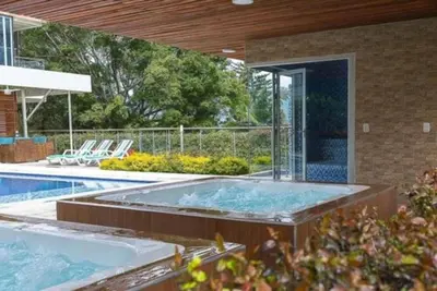 a swimming pool with a hot tub in a house at Libertg Hotels Medellin in Copacabana