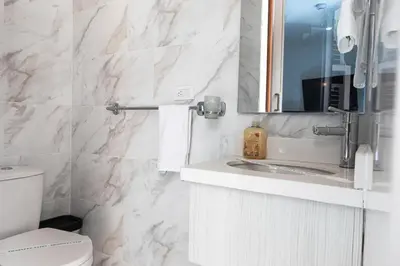 a bathroom with a sink and a toilet and a mirror at Libertg Hotels Medellin in Copacabana