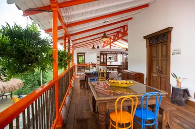 a room with a table and chairs on a balcony at Finca La Manchuria in Salgar