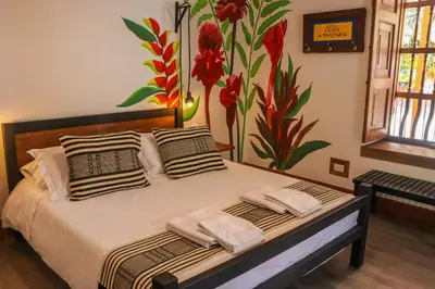 a bedroom with a bed with a flower mural on the wall at Finca La Manchuria in Salgar