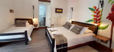 a hotel room with two beds and a bathroom at Finca La Manchuria in Salgar