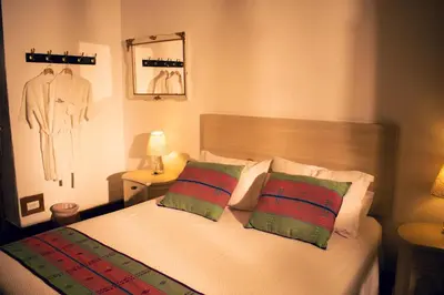 a bedroom with a bed with green and red pillows at Finca La Manchuria in Salgar