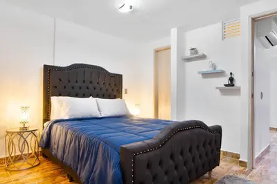 a bedroom with a black bed with a blue comforter at Miracle in Medellín