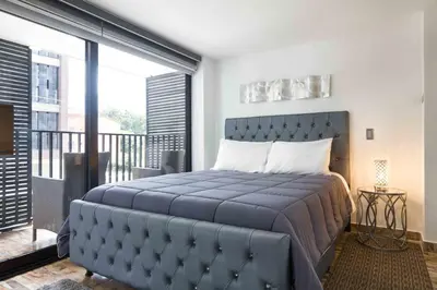 a bedroom with a large bed and a balcony at Miracle in Medellín