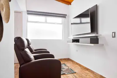 a living room with two chairs and a television at Miracle in Medellín