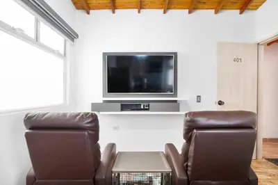 a living room with two chairs and a flat screen tv at Miracle in Medellín