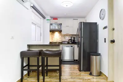 a kitchen with a refrigerator and two bar stools at Miracle in Medellín