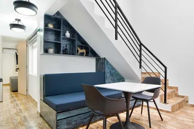 a dining room with a table and chairs and stairs at Miracle in Medellín