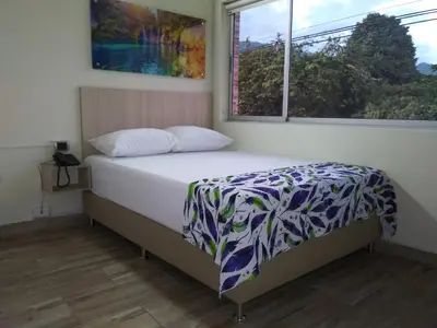 a bedroom with a bed and a window at Hotel Boutique Street 50 in Medellín