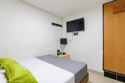 a bedroom with a bed and a flat screen tv at Hotel Colombia Avenida in Medellín