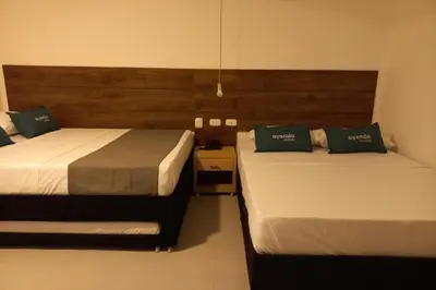 two beds in a hotel room with two beds sidx sidx sidx at Hotel Colombia Avenida in Medellín
