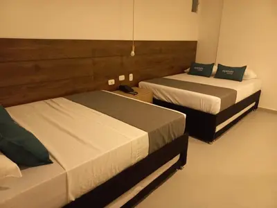 two beds in a hotel room with two beds at Hotel Colombia Avenida in Medellín