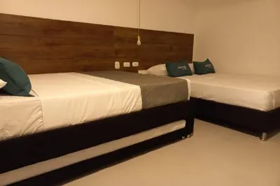 two beds in a hotel room with two beds sidx sidx sidx at Hotel Colombia Avenida in Medellín