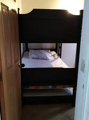 a black bunk bed in a room with a bed sqor at Apartamento de Guatapé in Guatapé