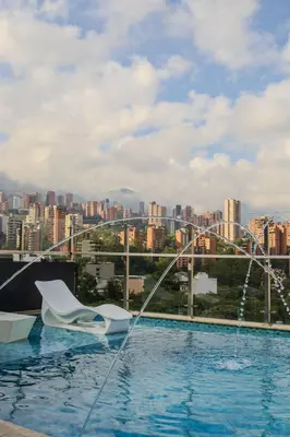 a swimming pool on top of a building with a city at Haven, A Design Hotel in Medellín