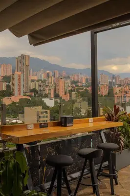 a bar with stools and a view of a city at Haven, A Design Hotel in Medellín