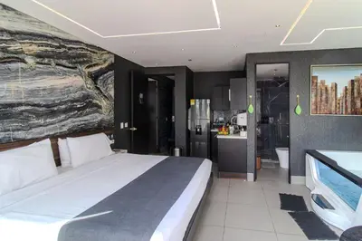 a bedroom with a large bed and a bathroom at Haven, A Design Hotel in Medellín
