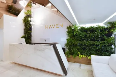 a lobby with a green wall and a white couch at Haven, A Design Hotel in Medellín