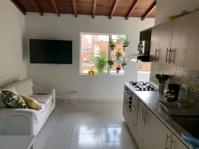 a living room with a couch and a kitchen at Apartamento remodelado en el mejor sitio del centro de Medellín Home Aris 401 in Medellín