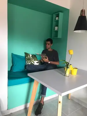 a man sitting on a couch with a laptop at Apartamento remodelado en el mejor sitio del centro de Medellín Home Aris 401 in Medellín