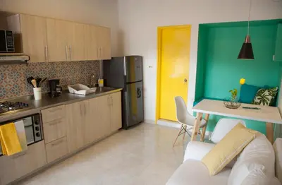 a kitchen with a white couch and a yellow door at Apartamento remodelado en el mejor sitio del centro de Medellín Home Aris 401 in Medellín