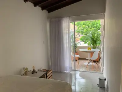 a bedroom with a bed and a patio with a table at Apartamento remodelado en el mejor lugar del centro de Medellín. Home Aris 402 in Medellín