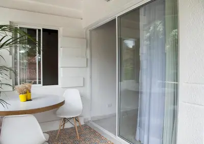 a glass balcony with a table and two white chairs at Apartamento remodelado en el mejor lugar del centro de Medellín. Home Aris 402 in Medellín