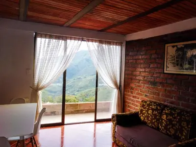 a living room with a couch and a large window at Casa Descanso en el Campo con Hermosa Vista a los Farallones in Versalles