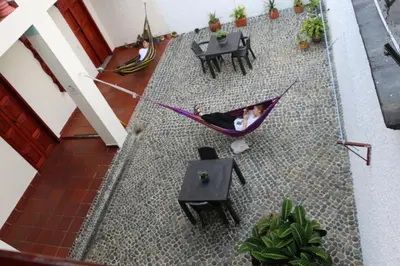 a woman laying in a hammock in a room at Candileja by Origen Hostel in Jardin