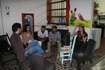 a group of people sitting in a living room at Candileja by Origen Hostel in Jardin