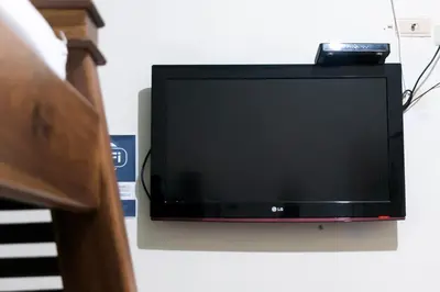 a flat screen tv hanging on a wall at Candileja by Origen Hostel in Jardin