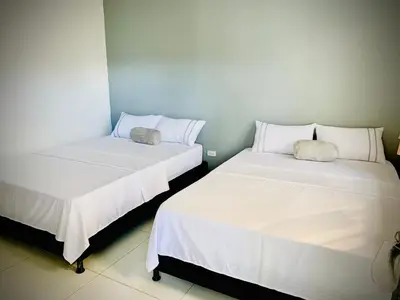 two beds sitting next to each other in a room at Hotel Los Mangos in San Luis
