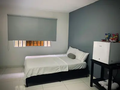 a small bedroom with a bed and a window at Hotel Los Mangos in San Luis