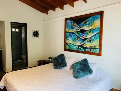 a bedroom with a bed with a painting on the wall at Hotel Lleras Premium #1 in Medellín