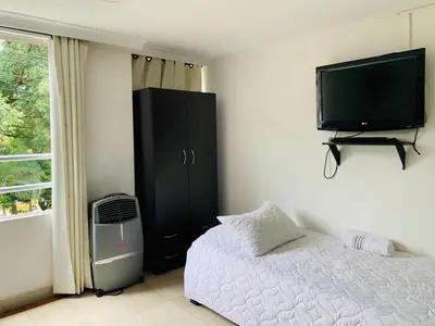 a bedroom with a bed and a tv on the wall at Hotel Lleras Premium #1 in Medellín