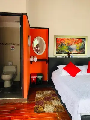 a room with two beds and a toilet in it at Hotel Lleras Premium #1 in Medellín